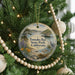 A round ornament hanging on a Christmas tree, featuring a scenic image of Tomales Bay State Park, California.