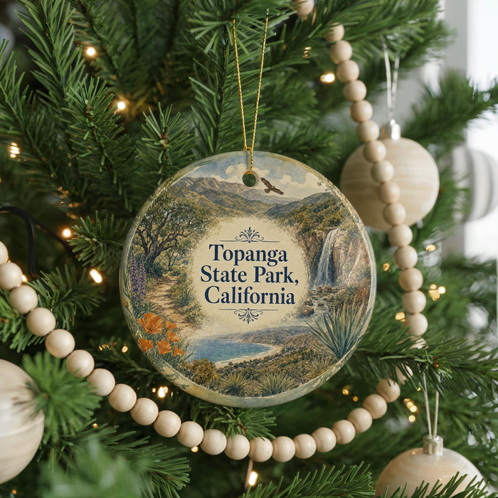 A Christmas tree decorated with ornaments, including a circular ornament with a scenic landscape of Topanga State Park, California.