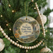 A Christmas tree decorated with ornaments, including a circular ornament with a scenic landscape of Topanga State Park, California.