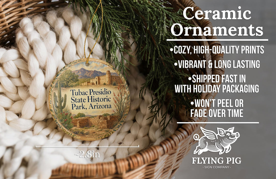 Ceramic ornaments, featuring a round ornament with a desert landscape and a bird, placed in a woven basket.