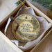A round ornament with a deer and a bird, surrounded by a natural landscape, is displayed in a box.
