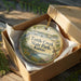 A decorative ornament in a brown box, featuring a scenic image of Tuttie Creek State Park in Kansas.