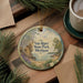 A round ornament with a scenic landscape of Van Riper State Park, Michigan, featuring pine trees, a lake, and a mountain.