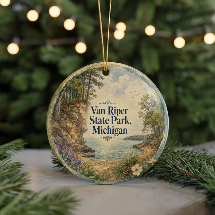 A round ornament with a scenic landscape of Van Riper State Park, Michigan, featuring a lake, mountains, and pine trees.