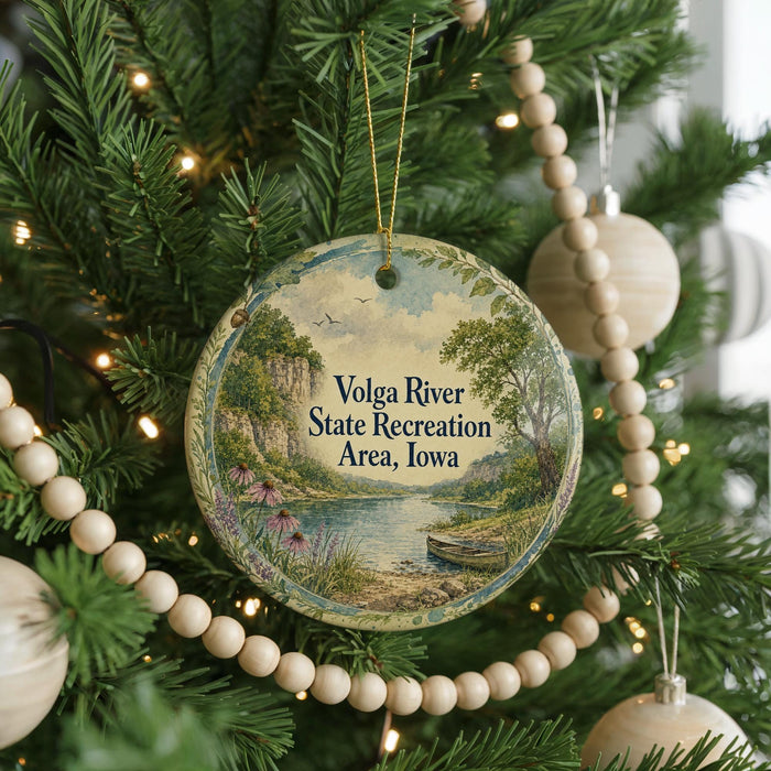 A Christmas tree decorated with ornaments, including a round ornament with a scenic landscape and text that reads "Volga River State Recreation Area, Iowa".