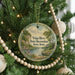 A Christmas tree decorated with ornaments, including a round ornament with a scenic landscape and text that reads "Volga River State Recreation Area, Iowa".