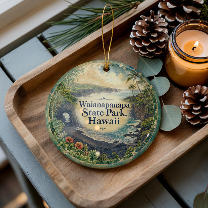 A decorative ornament featuring a scenic view of Waianapapa State Park, Hawaii, with pine cones and a lit candle on a wooden tray.