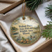 A round ornament with a scenic illustration of walnuts, birds, and a body of water, hanging from a string.