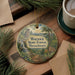 A circular ornament featuring a scenic landscape of the Warwick State Forest in Massachusetts, with a waterfall, pine trees, and a sign indicating hiking trails.