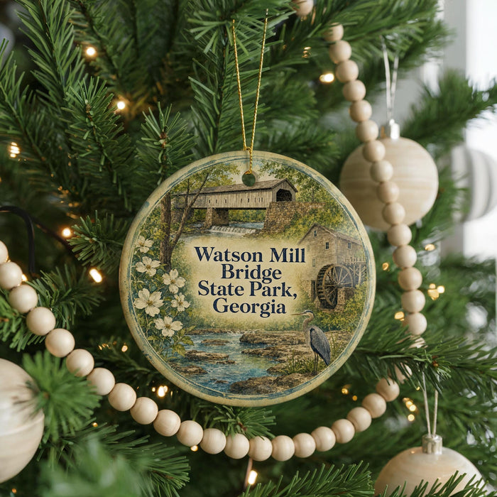A round ornament hanging on a Christmas tree, featuring an illustration of the Watson Mill Bridge in Georgia.