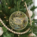A round ornament hanging on a Christmas tree, featuring an illustration of the Watson Mill Bridge in Georgia.
