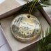 A decorative ornament in a box, featuring an illustration of the towers of Simon Rodia State Historic Park, California.