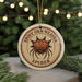 A round ornament with a spiny spider design, featuring the text "SPINY ORB-WEAVER SPIDER" on it.