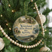 A circular ornament hanging on a Christmas tree, featuring a scenic image of a historic site in Kentucky.