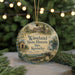 A round ornament with a painting of a historic site, surrounded by greenery and twinkling lights.