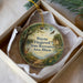 A round ornament with a painting of a deer and a bird, surrounded by a forest scene, is displayed in a white box.