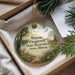 A round ornament with a scenic landscape featuring a deer, a path, and a body of water, hanging from a string.