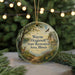 A round ornament with a scenic landscape featuring a deer, a bird, and a path, hanging from a string.