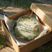 A wooden box containing a decorative ornament with a landscape scene and text that reads "Wayne Fitzgerald State Recreation Area, Illinois".