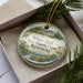 A decorative ornament in a box, featuring a house and trees, with the text "White Hall State Historic House, Kentucky" printed on it.