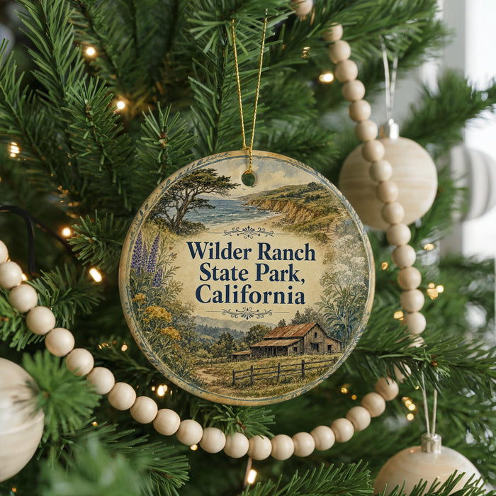 A round ornament hanging on a Christmas tree, featuring a scenic landscape with a house and trees.