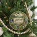 A round ornament hanging on a Christmas tree, featuring a scenic image of Willard Brook State Forest in Massachusetts.