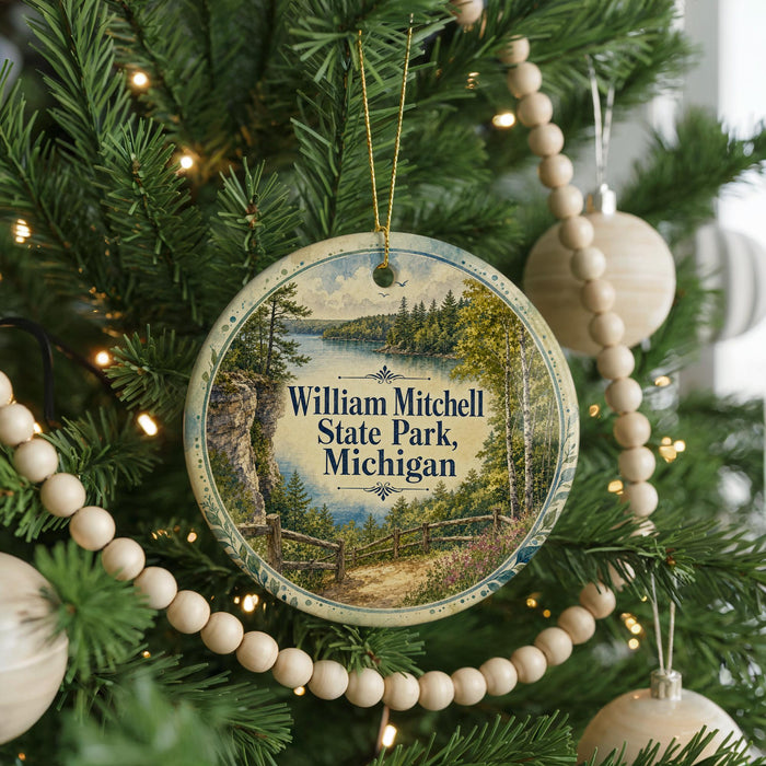 A round ornament hanging on a Christmas tree, featuring a scenic image of William Mitchell State Park, Michigan.