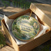 A decorative ornament in a brown box, featuring a scenic landscape with a river, trees, and a bird, along with the text "Wilmington State Parks, Delaware".