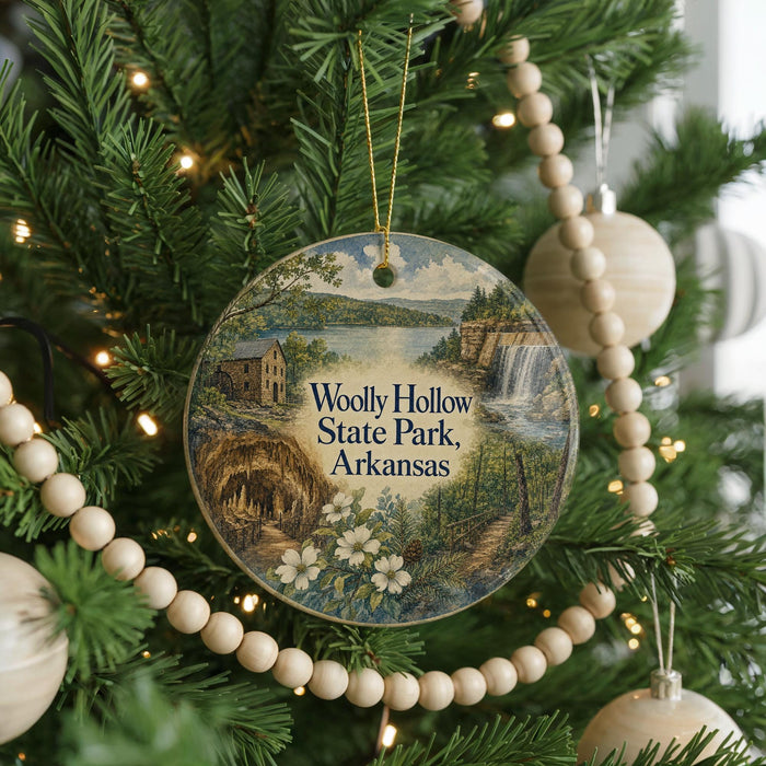 A round ornament hanging on a Christmas tree, featuring a scenic landscape with a waterfall and a house.
