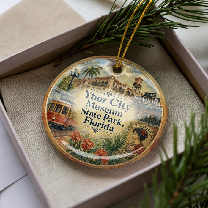 A decorative ornament in a box, featuring a collage of images related to the Ybor City Museum in Florida.