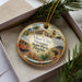 A decorative ornament in a box, featuring a collage of images related to the Ybor City Museum in Florida.