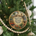 A circular ornament hanging on a Christmas tree, featuring an illustration of a trolley car and the text "Ybor City Museum State Park, Florida".
