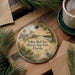A decorative ornament featuring a scenic image of the Yellow Bluff Fort Historic State Park in Florida, surrounded by pine branches and a cup of coffee.