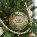 A circular ornament hanging on a Christmas tree, featuring a scenic image of Young State Park, Michigan.