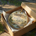 A decorative ornament in a wooden box, featuring an illustration of a historical building and landscape, with the text "Yuma Quartermaster Depot State Historic Park, Arizona" printed on it.