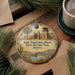 A decorative ornament featuring a painting of Yuma Territorial Prison in Arizona, surrounded by desert scenery and a bridge.