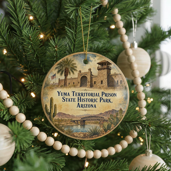 A round ornament hanging on a Christmas tree, featuring an illustration of Yuma Territorial Prison State Historic Park, Arizona.