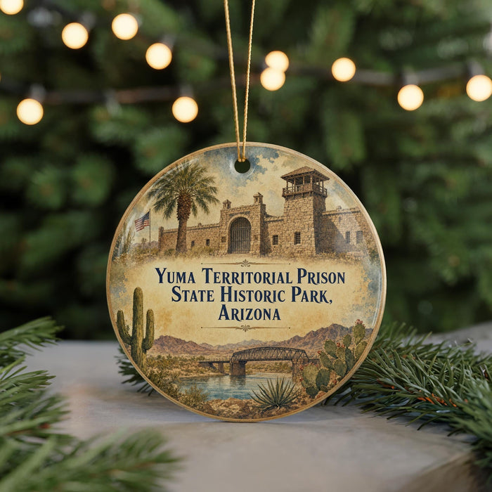 A round ornament featuring an illustration of Yuma Territorial Prison, a historic park in Arizona, with a desert landscape and a bridge in the background.