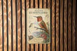 A vintage-style metal sign with illustrations and text, mounted on a wooden wall.