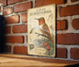 A vintage-style metal sign featuring an illustration of a hummingbird, mounted on a brick wall.