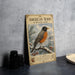 A vintage-style metal sign featuring an illustration of an American robin in winter snow, with text describing the bird and its habitat.