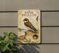 a sign with a picture of a bird, specifically a swallow, perched on a rock. The sign is mounted on a wall and is surrounded by greenery, including a plant.