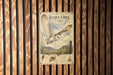 a poster of a barn owl in flight, mounted on a wooden wall.