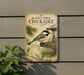 A vintage-style sign for a field guide to black-capped chickadees, featuring illustrations of the birds and their natural habitat.