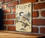 a vintage-style illustration of a black-capped chickadee perched on a branch, with a brick wall in the background.