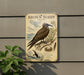 a vintage-style metal sign with a bird illustration, mounted on a wall next to a plant.