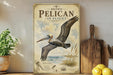A vintage-style poster of a pelican in flight, featuring illustrations of the bird and its natural habitat, is displayed on a wall next to a wooden cutting board and some potted plants.
