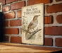 A vintage-style metal sign with a brown thrush illustration is mounted on a brick wall.