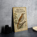 a vintage-style field guide to North American birds, specifically the Brown Thrasher, which is displayed on a table.