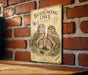 a vintage-style sign with illustrations of owls, mounted on a brick wall.